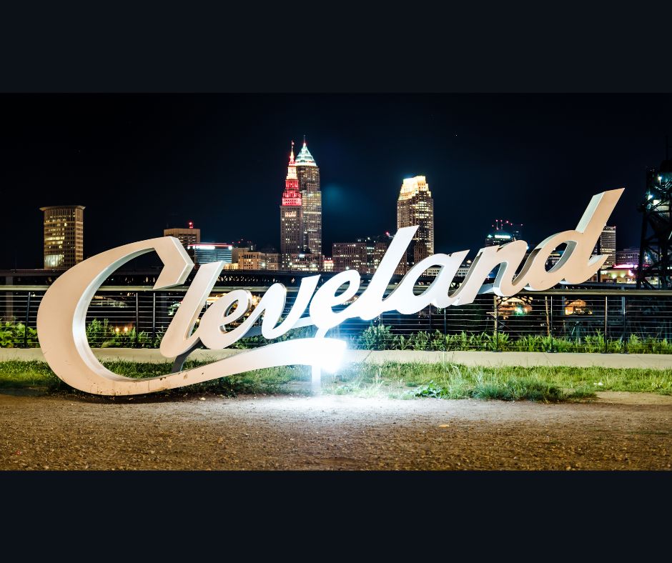 Cleveland titled sign with Cleveland Ohio Downtown Skyline in background at Night.